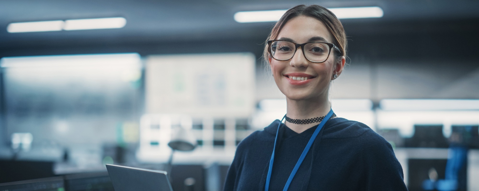Woman in glasses working on a laptop in an office, representing commercial recruitment