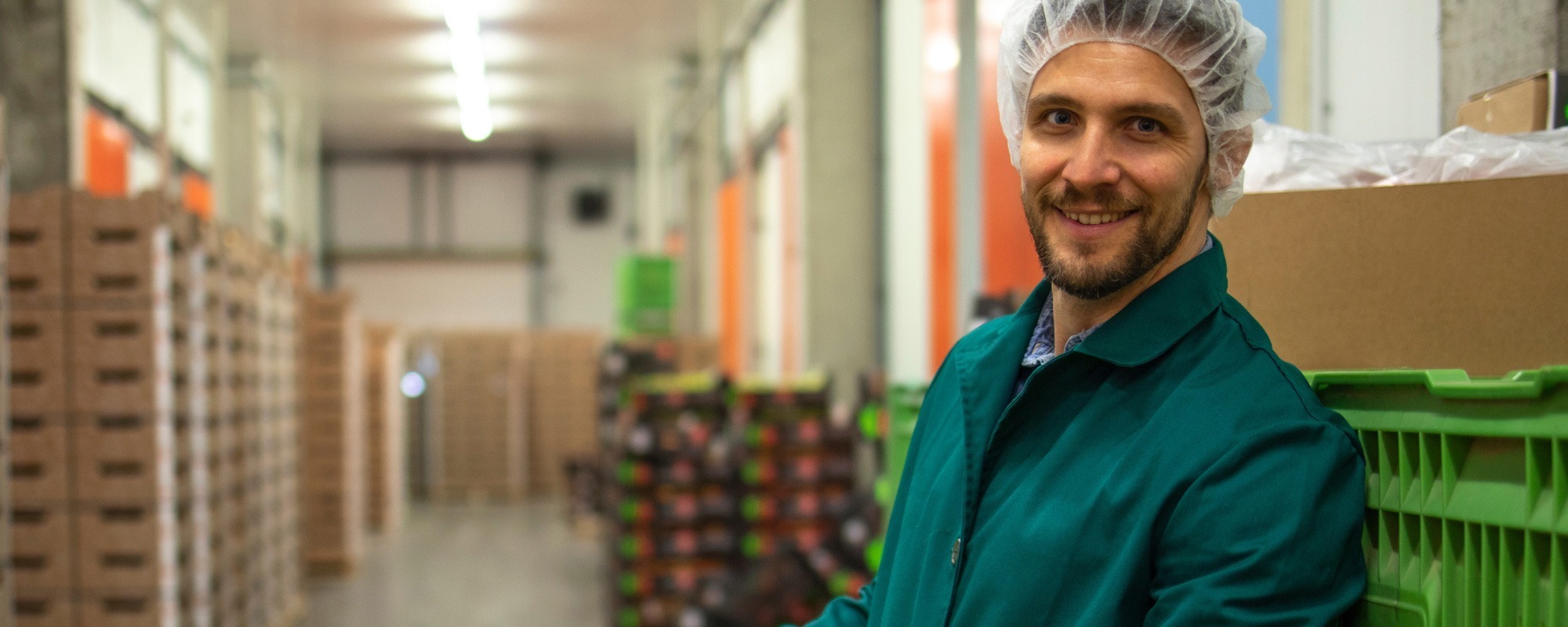 Man wearing a hairnet working in a food production facility