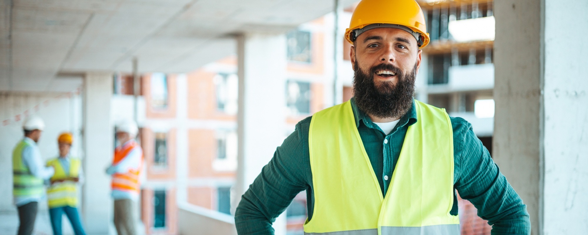 Man in high-visibility vest and hard hat working in a construction environment