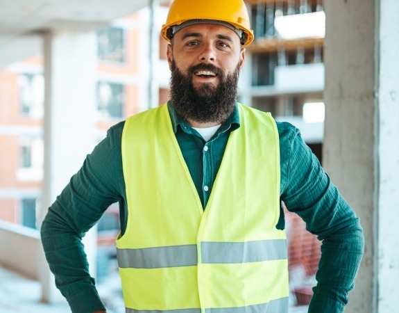 Man in high-visibility vest and hard hat working in a construction environment
