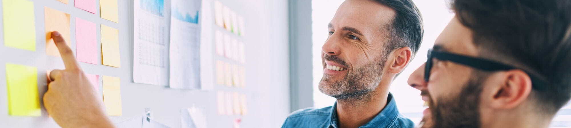 Two recruiters smiling looking at a whiteboard   